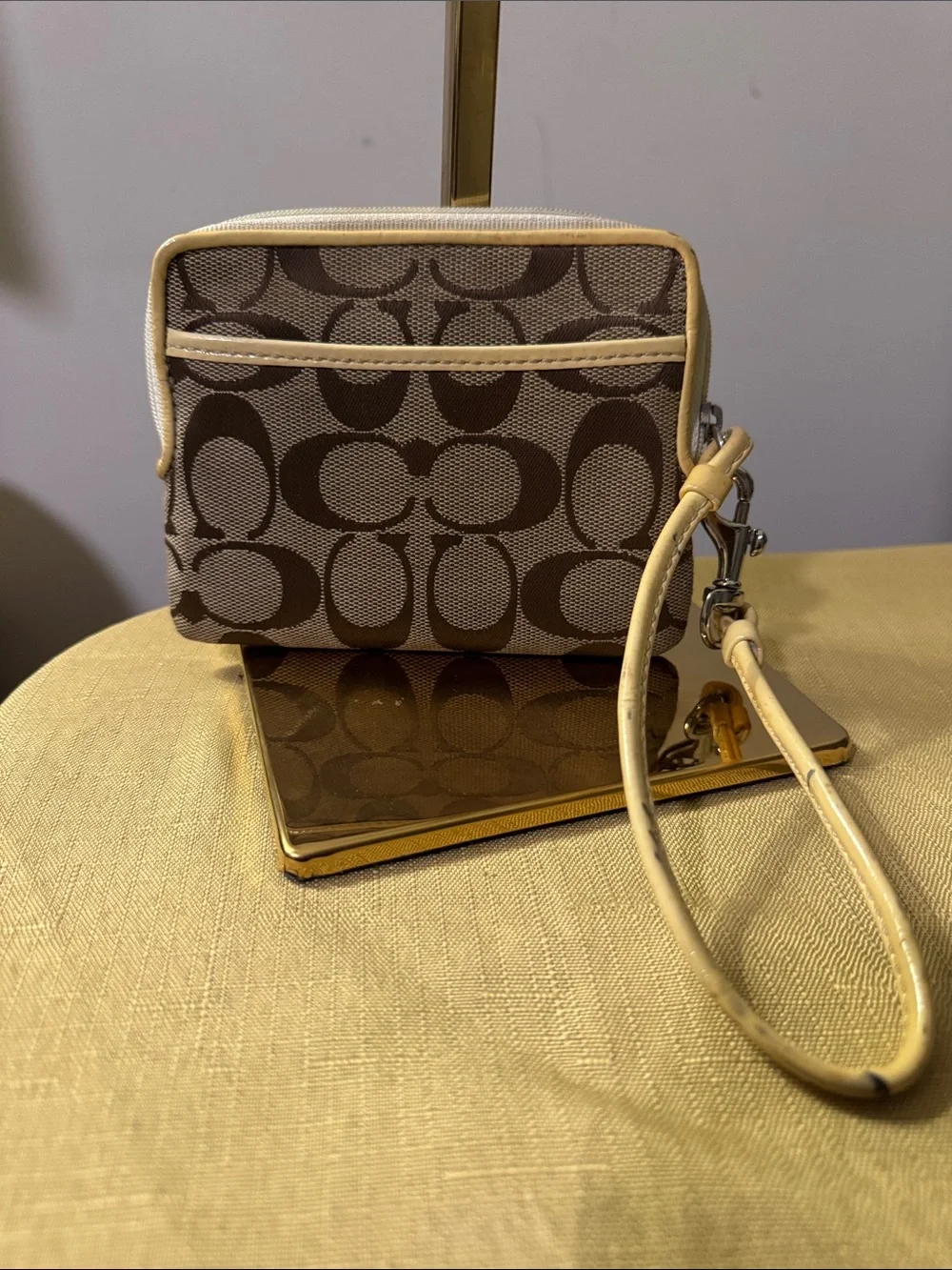 This is a Coach Poppy Signature Wristlet featuring the iconic C pattern